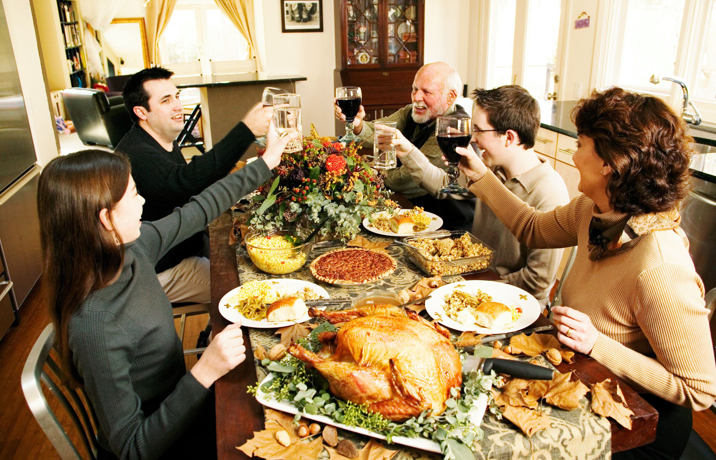 Жирный ужин. Праздничный стол с людьми. Праздничный обед. День Благодарения застолье. Богатый стол с едой.